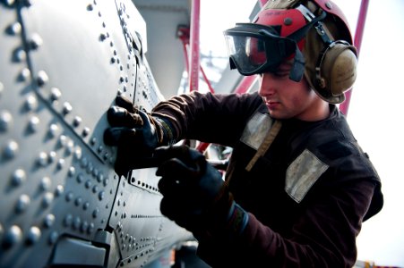 US Navy 110902-N-BT887-049 Airman Logan Grady secures the tail of an MH-60R Sea Hawk helicopter aboard USS John C. Stennis (CVN 74)