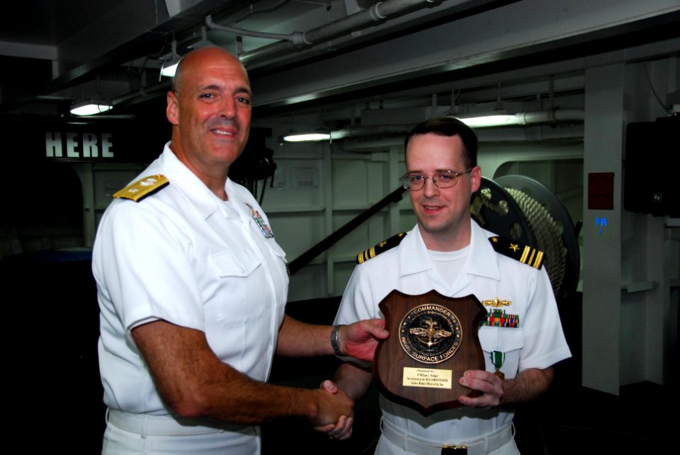 US Navy 110829-N-KF029-154 Rear Adm. Robert Girrier, commander of Carrier Strike Group (CSG) 7, presents Lt. Cmdr. William Blodgett with the Surfac