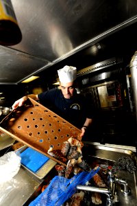 US Navy 110829-N-YZ751-030 Culinary Specialist 3rd Class Alexander R. Laduca prepares lobsters for the crew aboard the guided-missile destroyer USS