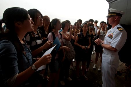 US Navy 110902-N-RC734-005 Cmdr. Lance Lesher, commanding officer of the amphibious dock landing ship USS Comstock (LSD 45), greets journalism stud