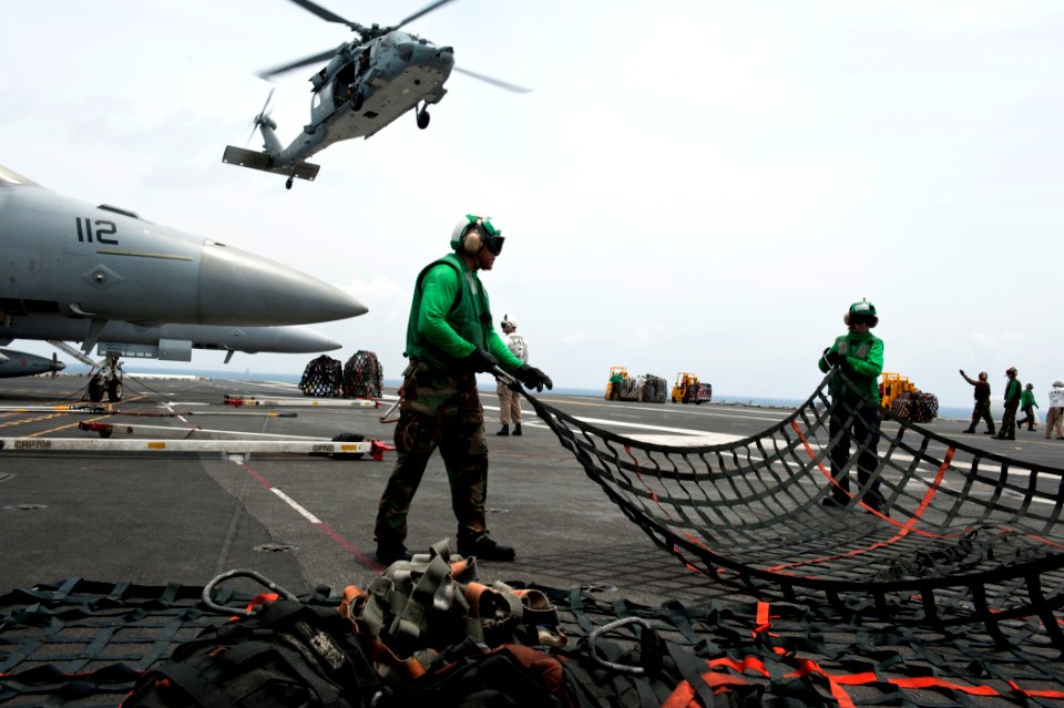 US Navy 110830-N-BT887-104 Sailors bundle cargo nets during a vertical replenishment aboard the Nimitz-class aircraft carrier USS John C. Stennis (