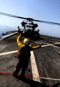 US Navy 110903-N-CT127-048 Aviation Boatswain's Mate (Handling) 3rd Class Eddy Parra gives hand signals to a CH-53 Sea Stallion helicopter aboard U