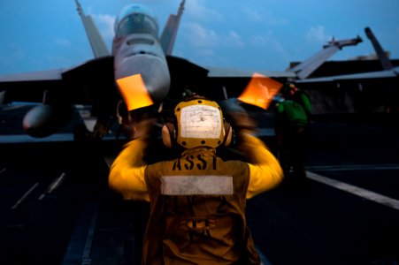 US Navy 110901-N-BT887-154 Aviation Boatswain's Mate 2nd Class Thanh Dai directs an F-A-18F Super Hornet aboard USS John C. Stennis (CVN 74)