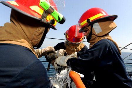 US Navy 110902-N-YZ751-044 Sailors patch a simulated punctured fire hose during a damage control exercise aboard the guided-missile destroyer USS