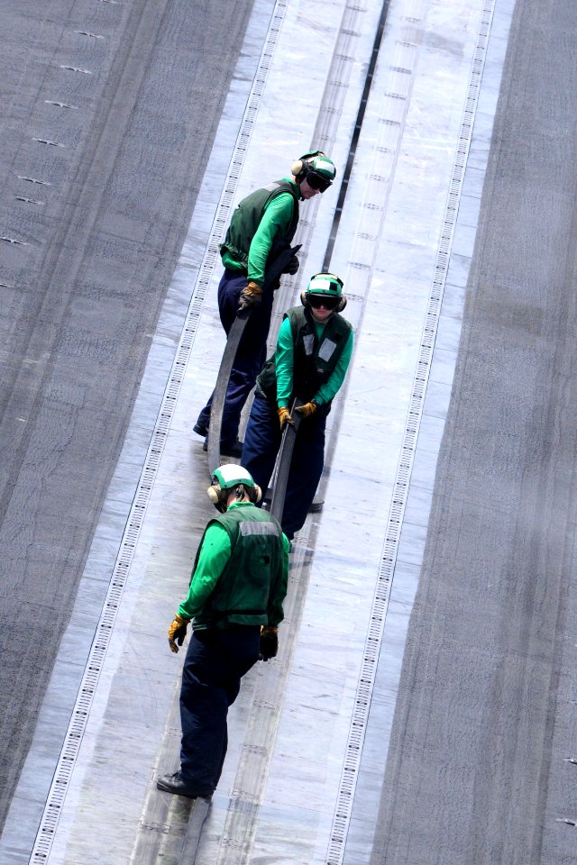 US Navy 110906-N-QL471-225 Sailors insert slot seals into a catapult on the flight deck of the aircraft carrier USS George H.W. Bush (CVN 77)