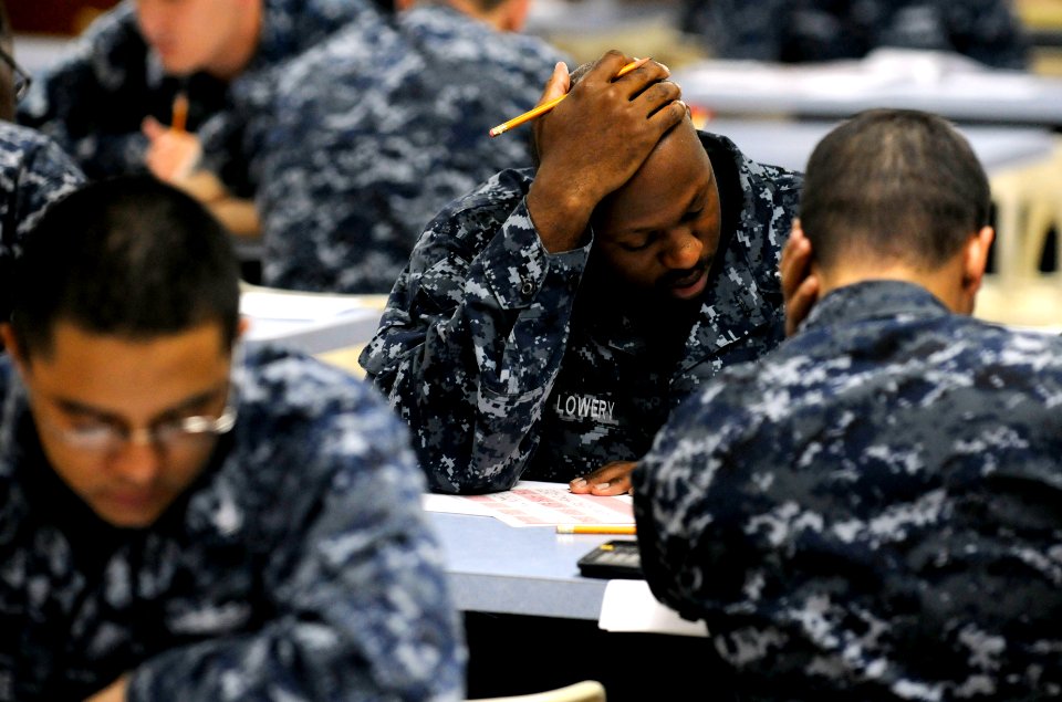US Navy 110901-N-XG305-051 Logistics Specialist 2nd Class Reginald Lowery takes the first class petty officer advancement exam on the mess decks ab