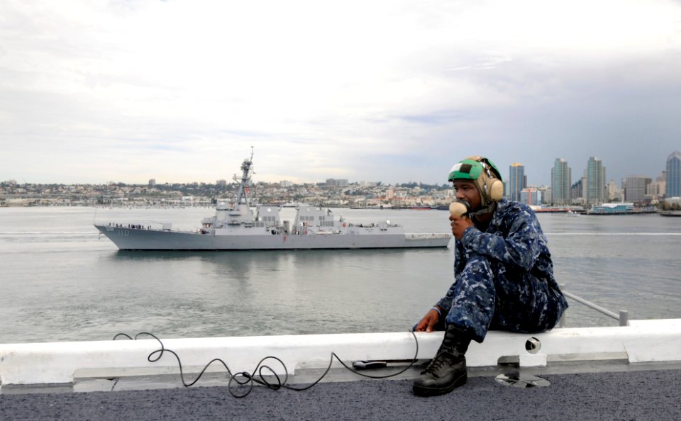 US Navy 110906-N-GZ277-017 Aviation Boatswain's Mate (Equipment) Airman Columbus Heard Jr. relays a message on the flight deck of the Nimitz-class