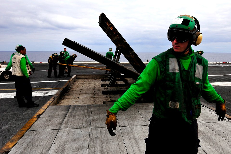 US Navy 110906-N-EE987-004 Aviation Boatswain's Mate Airman Jared Tello sets a safety boundary during a jet blast deflector demonstration drill abo