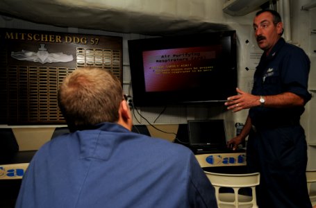 US Navy 110903-N-XQ375-139 Boatswain's Mate 1st Class Dave Mullins conducts respirator training on the mess deck aboard the guided-missile destroye