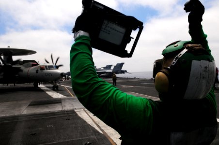 US Navy 110907-N-SB672-328 Aviation Boatswain's Mate (Equipment) Airman Andres Leal shows a weight board to the pilots of an E-2C Hawkeye during th