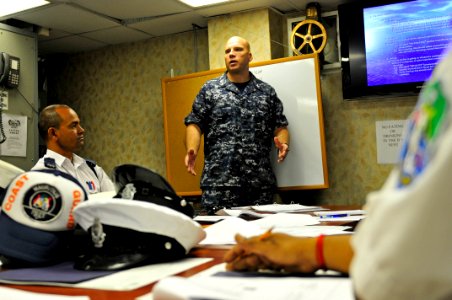 US Navy 110907-N-IZ292-043 Operations Specialist 1st Class Christian Lewis, a search and rescue planner, briefs members of the Mauritius Police For