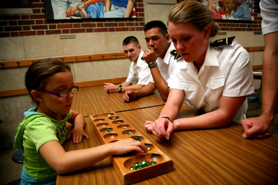 US Navy 110906-N-YM440-123 Midshipman 3rd Class Alyssa Wolken, a Navy ROTC member at the University of Nebraska, plays with a student at Everett El
