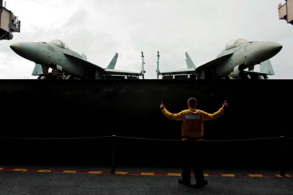 US Navy 110910-N-BT887-098 Aviation Boatswain's Mate (Handling) Airman Matt Clark, from Corona, Calif., gives the approval to raise the aircraft el