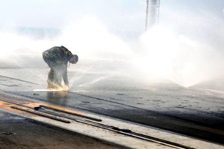 US Navy 110912-N-AU622-041 Aviation Boatswain's Mate (Handling) 3rd Class Zachary Stump inspects a sprinkler on the flight deck of the aircraft car