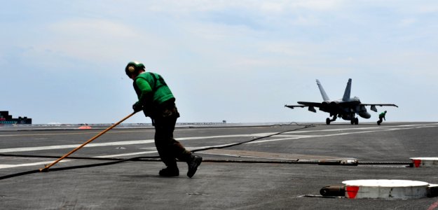US Navy 110909-N-OY799-247 Aviation Boatswain's Mate (Equipment) 3rd Class Aaron Rutledge retracts the arresting wire after an F-A-18F Super Hornet