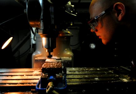 US Navy 110908-N-XE109-471 Machinery Repairman 2nd Class William M. Grabowski observes the cutting of door gauges in the repair shop aboard