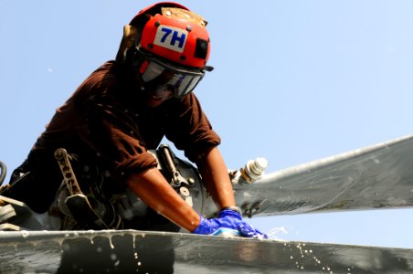 US Navy 110909-N-XE109-085 Airman Olmicha Vital cleans an MH-60R Sea Hawk helicopter aboard USS George H.W. Bush (CVN 77)