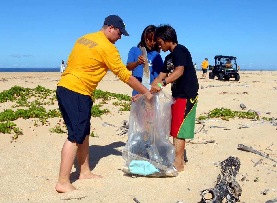 US Navy 110915-N-YU572-076 Aviation Maintenance Administrationman 2nd Class Devon Brandenburg and student volunteers collect trash along a beach at