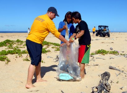 US Navy 110915-N-YU572-076 Aviation Maintenance Administrationman 2nd Class Devon Brandenburg and student volunteers collect trash along a beach at