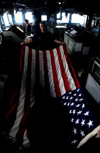 US Navy 110911-N-ZZ999-156 Quartermaster 3rd Class Andrew Harris and Religious Program Specialist 1st Class Johnathan Nutt fold the American flag a