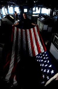 US Navy 110911-N-ZZ999-156 Quartermaster 3rd Class Andrew Harris and Religious Program Specialist 1st Class Johnathan Nutt fold the American flag a photo