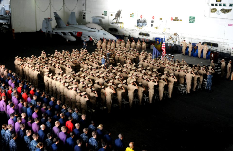US Navy 110916-N-QL471-062 Sailors salute the colors during the 2011 chief petty officer pinning ceremony aboard USS George H.W. Bush (CVN 77)