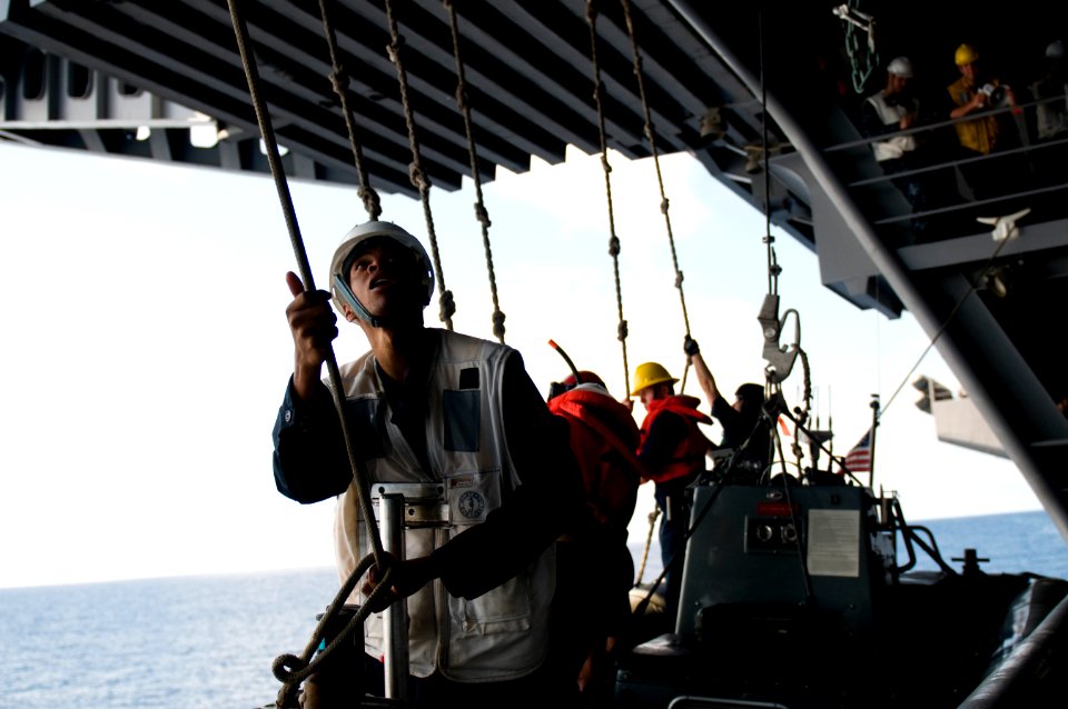 US Navy 110913-N-TZ605-168 Lt. j.g. Kevin Samuels, assigned to the deck department, secures a guide line during the recovery of a rigid hull inflat