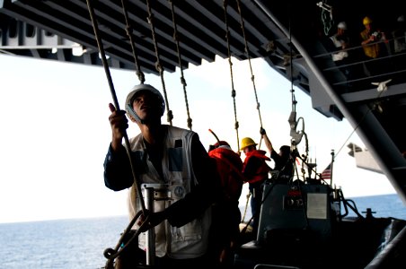 US Navy 110913-N-TZ605-168 Lt. j.g. Kevin Samuels, assigned to the deck department, secures a guide line during the recovery of a rigid hull inflat
