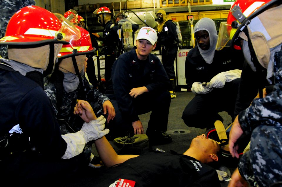 US Navy 110914-N-FH966-193 Hospital Corpsman 1st Class Melissa Gregg trains Sailors attending to a mock casualty during a general quarters drill