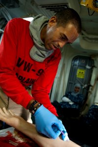 US Navy 110914-N-BT887-592 Chaplain Lt. John Keith, from Orange County, Calif., practices an IV procedure on a prosthetic arm during a general quar