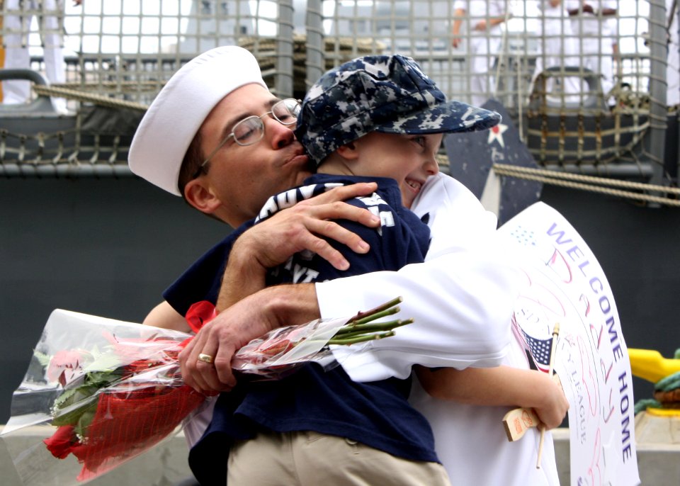 US Navy 110916-N-ZI300-193 Ship's Serviceman 2nd Class Nimitz Martin, assigned to the guided-missile frigate USS Thach (FFG 43), hugs his son after