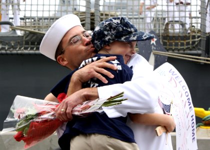 US Navy 110916-N-ZI300-193 Ship's Serviceman 2nd Class Nimitz Martin, assigned to the guided-missile frigate USS Thach (FFG 43), hugs his son after