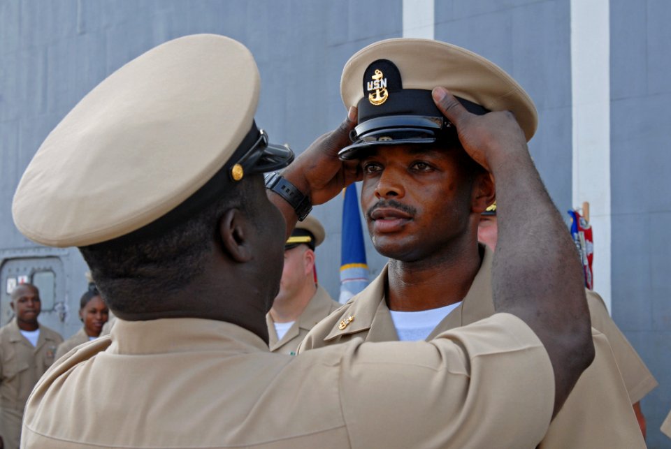 US Navy 110916-N-DU438-295 Chief Gunner's Mate James Glenn is presented his chief petty officer combination cover by Chief Electrician's Mate Josep