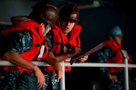 US Navy 110913-N-DR144-408 Boatswain's Mate 3rd Class Marcus Bjorklund reviews a personal qualification standard with Seaman David West