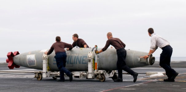 US Navy 110917-N-OK922-061 Sailors assigned to Strike Fighter Squadron (VFA) 22 transport air refueling pods across the flight-deck of the Nimitz-c photo