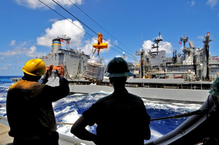 US Navy 110916-N-RC734-257 Boatswain's Mate 2nd Class Sheraul Gumbs, left, sends hand signals to Sailors aboard the Military Sealift Command fleet