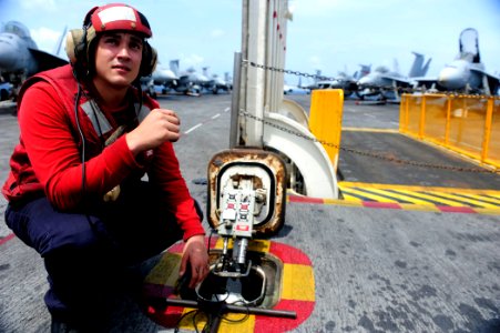 US Navy 110915-N-ZZ999-564 Aviation Ordnanceman Airman Apprentice Gonzalo Mendez, from Clinton, Mass., readies a weapons elevator on the flight dec