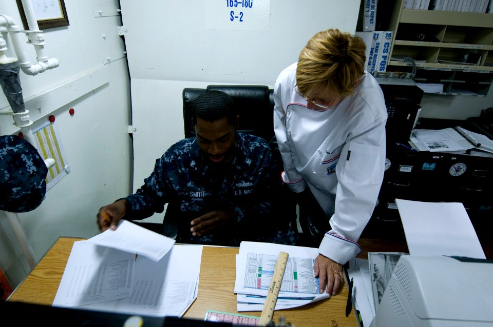US Navy 110913-N-MD252-519 Chief Warrant Officer Kathy Wiseman observes Culinary Specialist 3rd Class Luther Smith Jr. during a food service financ