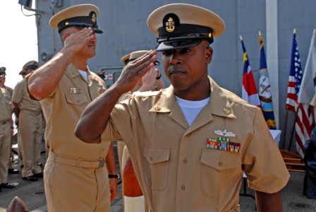 US Navy 110916-N-DU438-521 Chief Culinary Specialist Juan Yarborough salutes as he passes through side boys during the 2011 chief petty officer pin