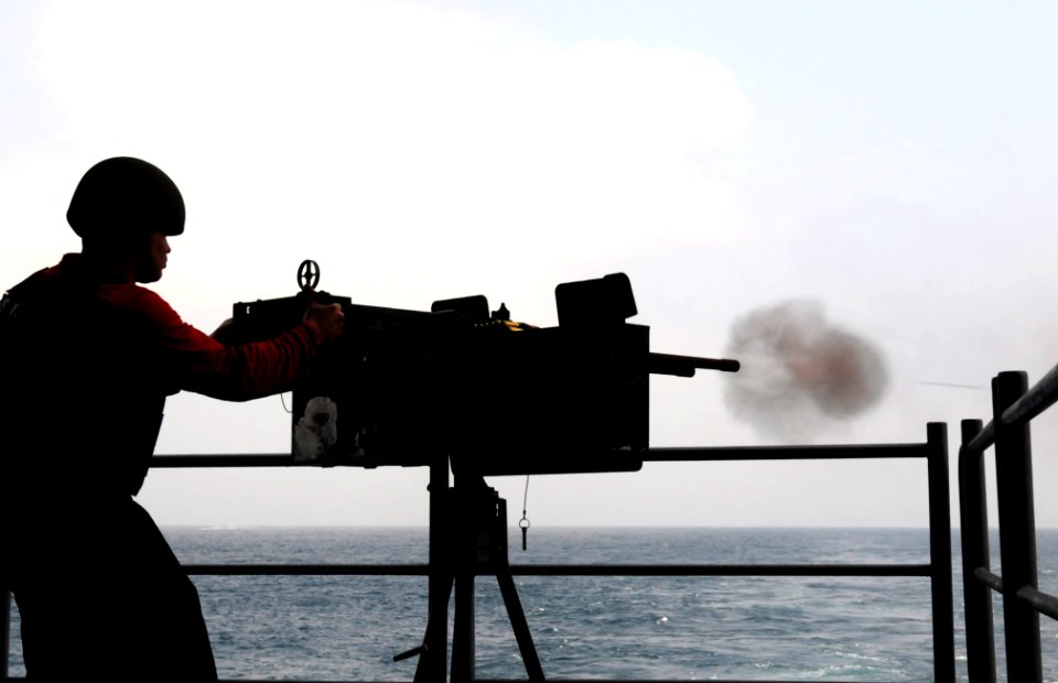 US Navy 110919-N-QJ471-503 Aviation Ordnanceman 3rd Class Gianfranco Francisco fires a .50-caliber machine gun during a live-fire exercise on the f