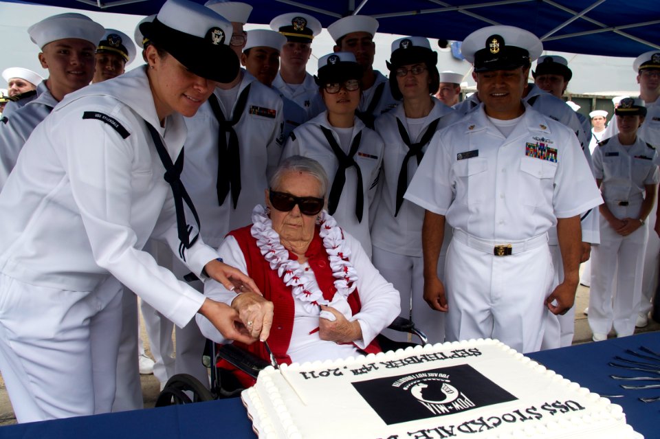 US Navy 110914-N-ZC343-551 Sybil Stockdale, widow of Adm. James B. Stockdale, cuts a cake during a ceremony to commemorate POW-MIA Day at Naval Bas