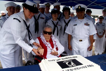 US Navy 110914-N-ZC343-551 Sybil Stockdale, widow of Adm. James B. Stockdale, cuts a cake during a ceremony to commemorate POW-MIA Day at Naval Bas