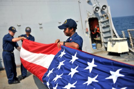US Navy 110916-N-YZ751-127 Fire Controlman 1st Class Tammie T. Moore helps fold a flag on the flight deck aboard the guided-missile destroyer USS T