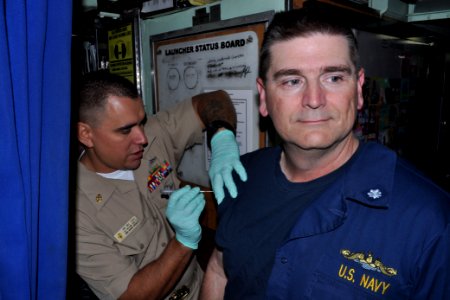 US Navy 110915-N-DI599-021 Chief Hospital Corpsman Michael Subee administers a flu vaccine to Cmdr. Gary Rogeness, commanding officer of the Los-An