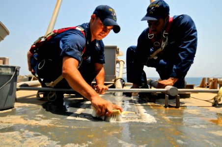US Navy 110915-N-YM590-004 Quartermaster 3rd Class Michael Martinez, left, and Quartermaster 3rd Class Jamarcus Hardy clean the top of the bridge