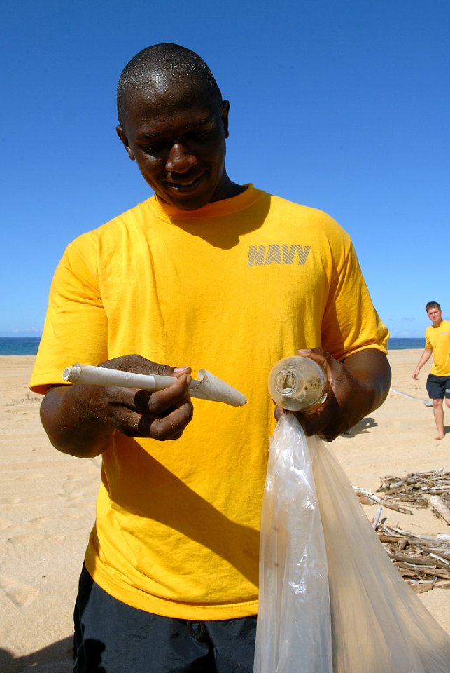 US Navy 110915-N-YU572-080 Electrician's Mate 2nd Class Jon Moore removes a message from a bottle sent from Kagoshima, Japan more than five years a