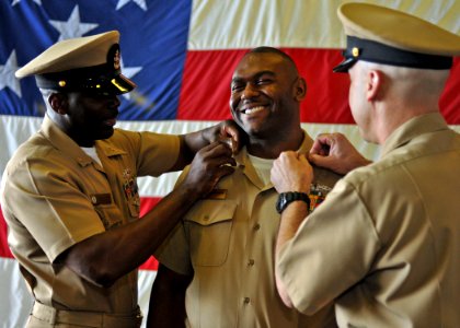 US Navy 110916-N-ZS026-203 Chief Hospital Corpsman David Toston, center, receives his collar devices from Senior Chief Boatswain's Mate Samuel Lewi