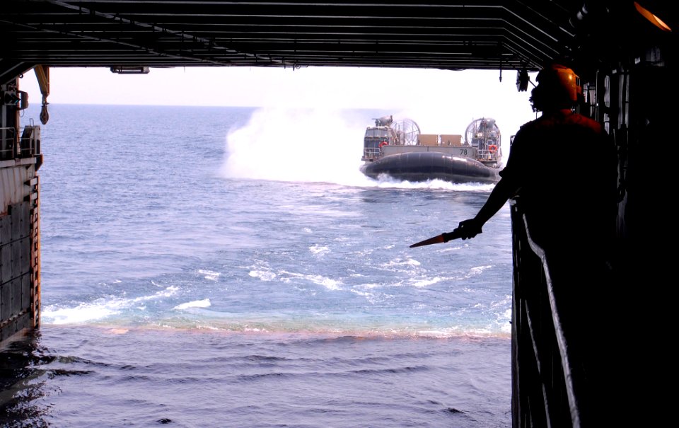 US Navy 110920-N-GH121-094 Boatswain's Mate 3rd Class Ronnie Guerra, from Union City, N.J., signals to operators aboard a landing craft air cushion photo