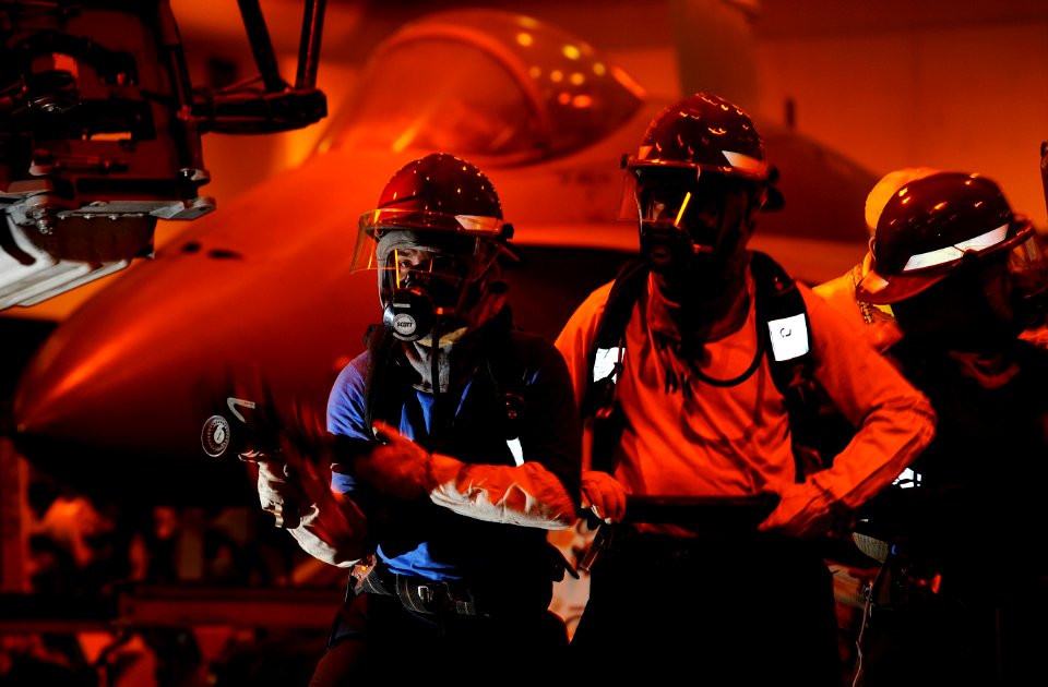 US Navy 110917-N-DR144-053 Sailors battle a simulated aircraft fire in the hangar bay during a general quarters drill aboard the Nimitz-class aircr