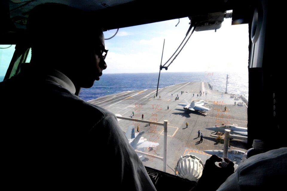 US Navy 110920-N-JO245-016 Aviation Boatswain's Mate (Handling) 3rd Class Daniel Brown, from Detroit, tracks aircraft on the flight deck in the pri